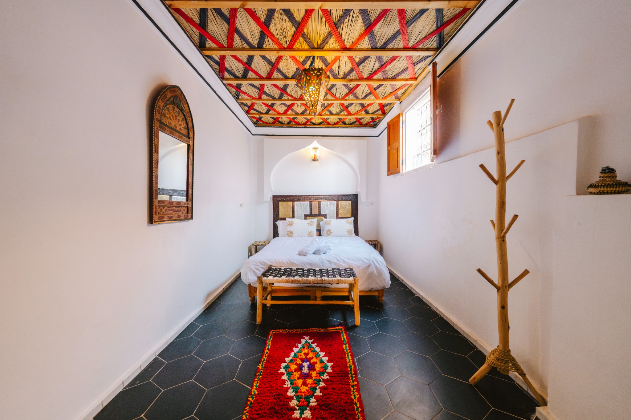 A bright bedroom with a traditionally woven ceiling