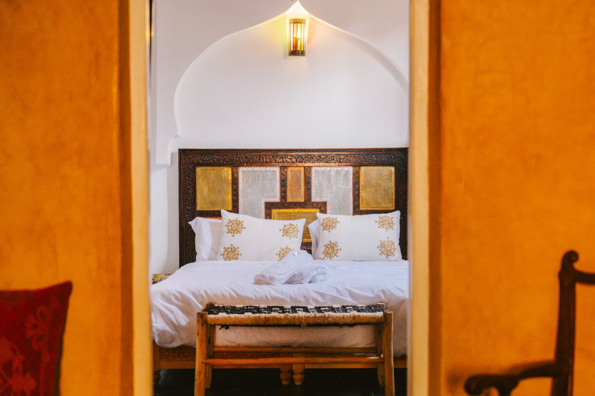 A bedroom in the warm light of the riad